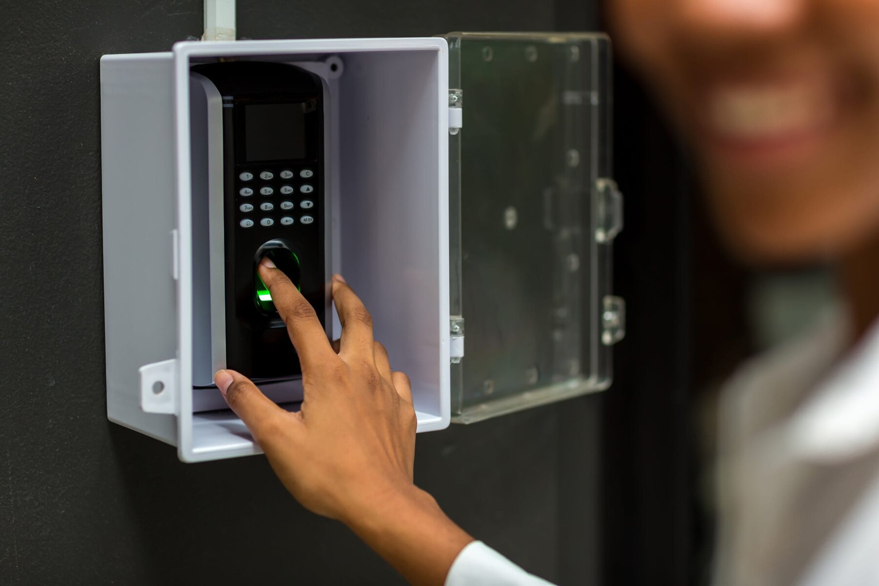 Close-up of a person's hand using a fingerprint scanner for access.