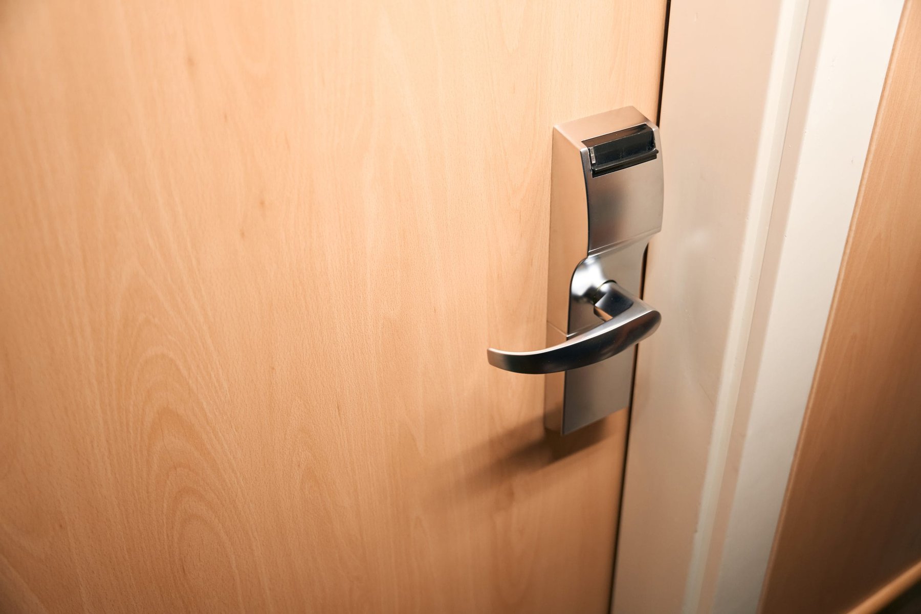 Close-up of a modern hotel room door with a key card lock.