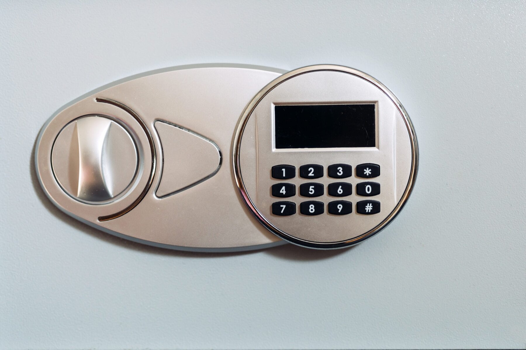 Close-up of a silver electronic safe lock with a keypad and display.