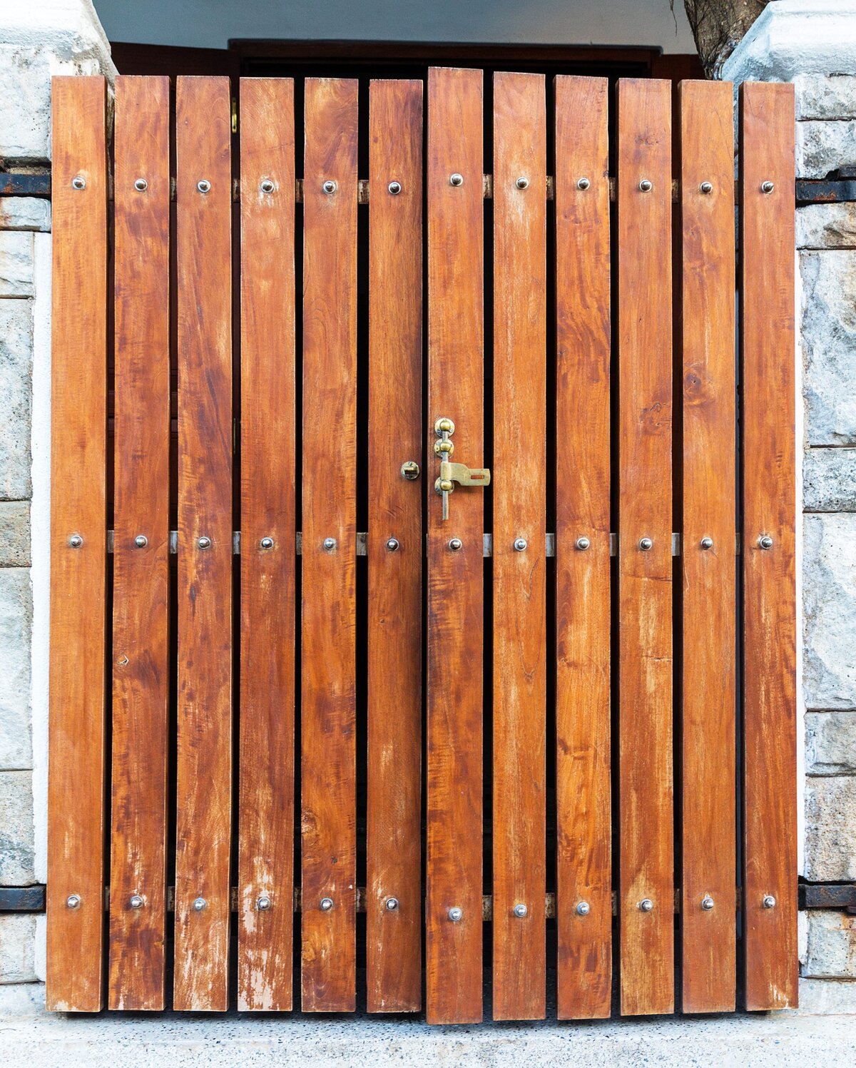 A rustic wooden gate with a golden lock and key.