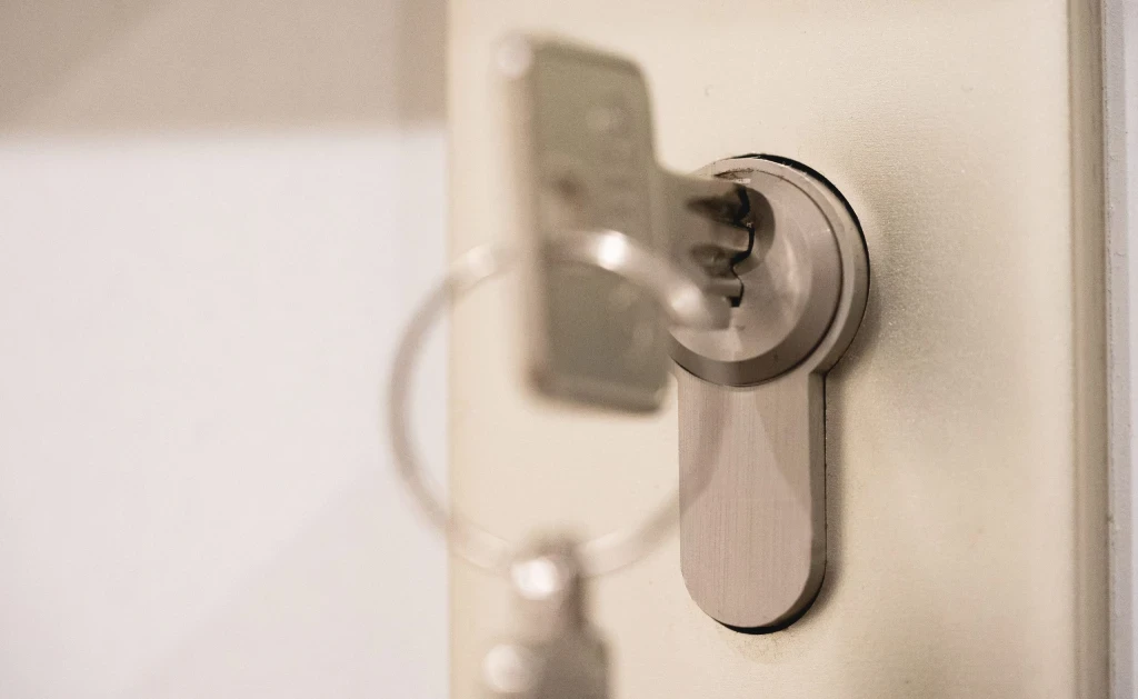 Close-up of a silver key inserted into a door lock.