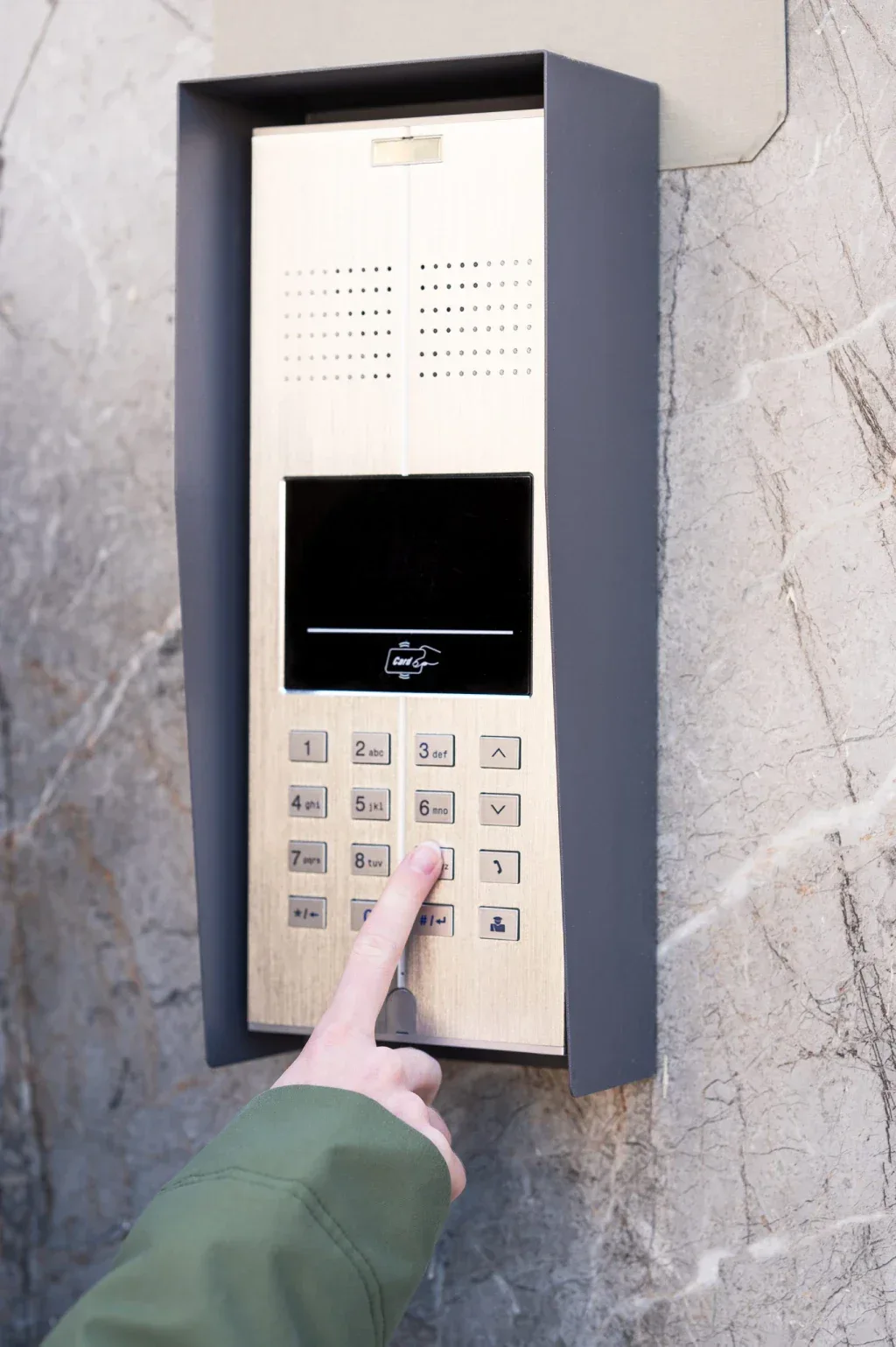 Person pressing button on a modern intercom system.