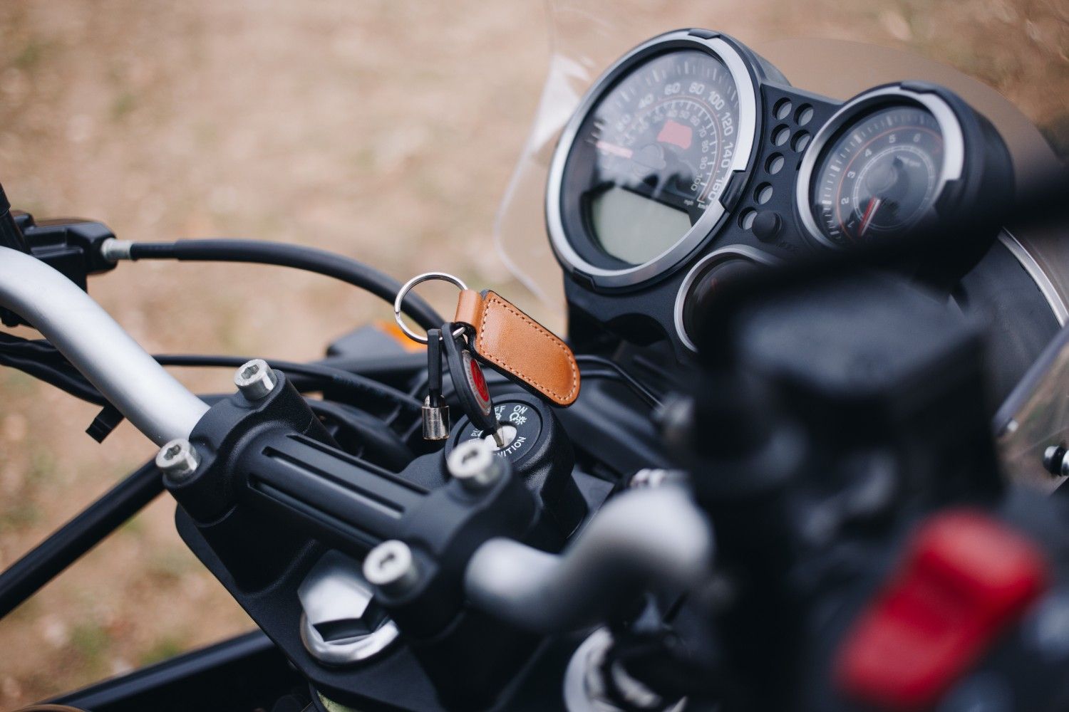 Close-up of a motorcycle dashboard with keys in the ignition