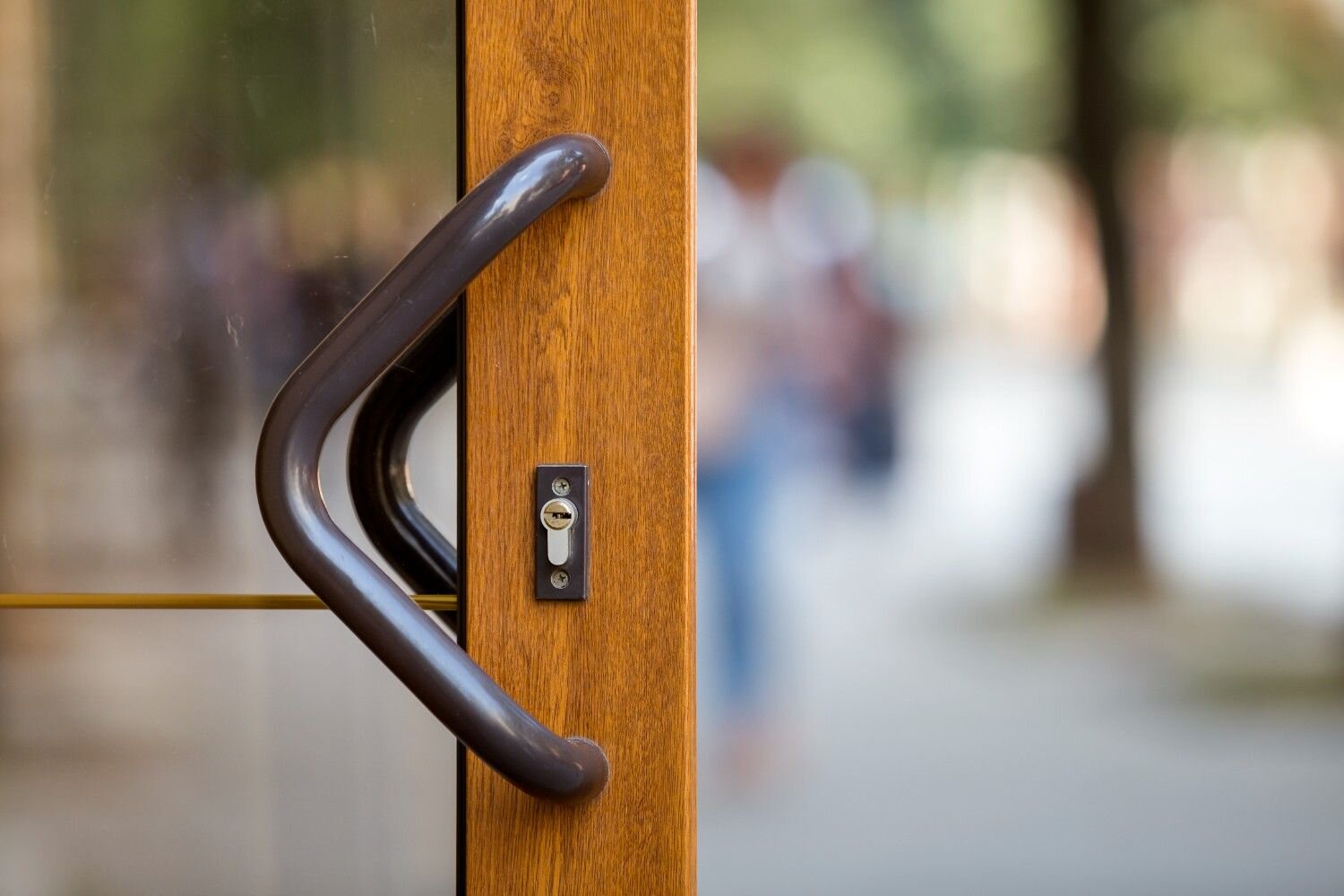 Close-up of a brown wooden door with a dark handle and keyhole