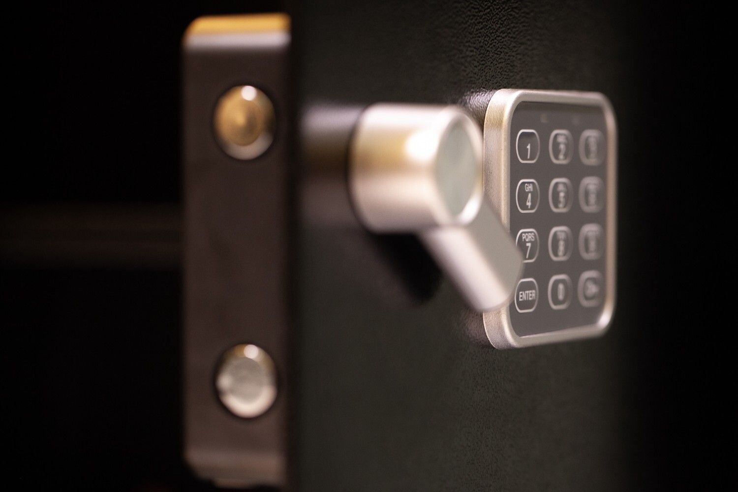 Close-up of a black safe with a silver electronic keypad and handle.