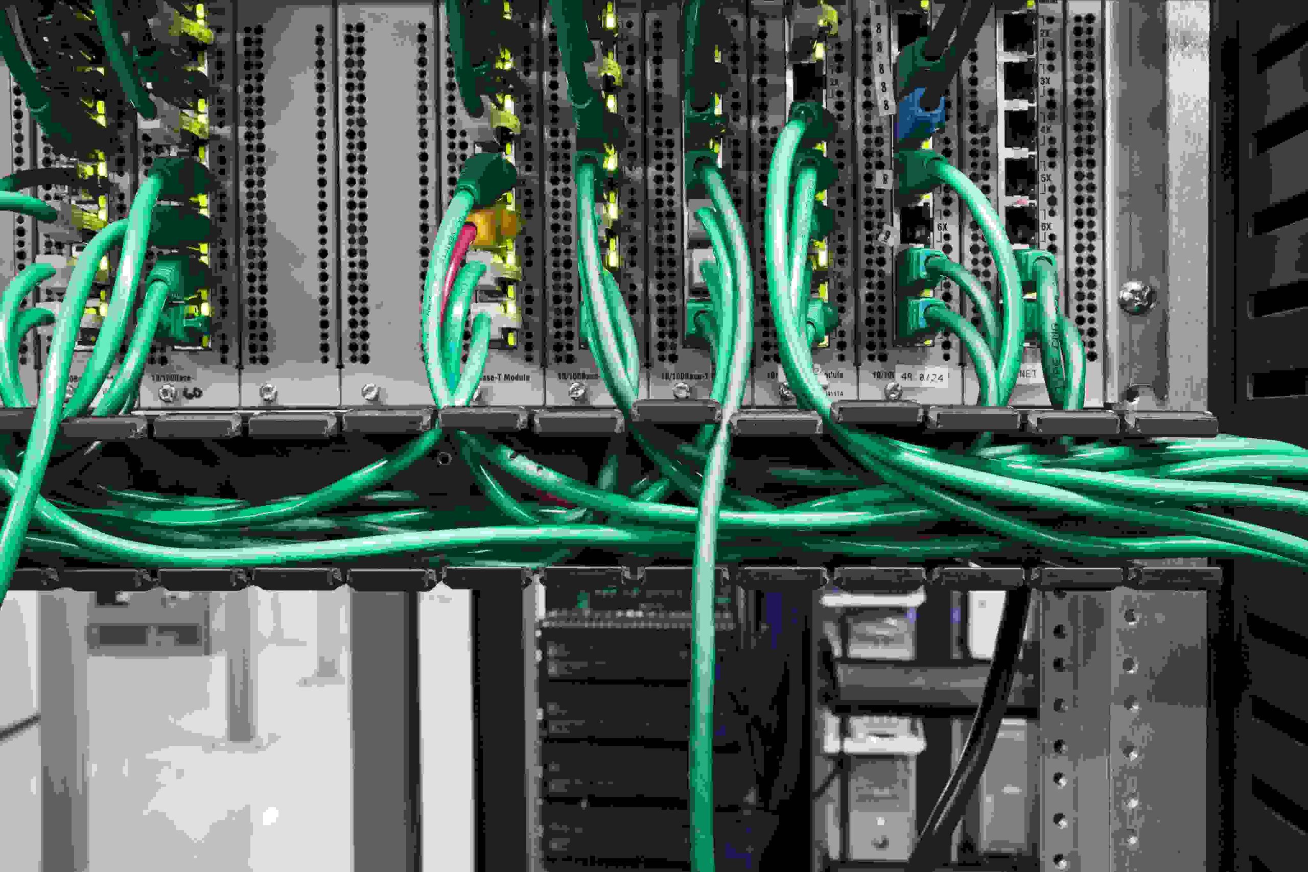 Close-up of network cables plugged into a server rack.