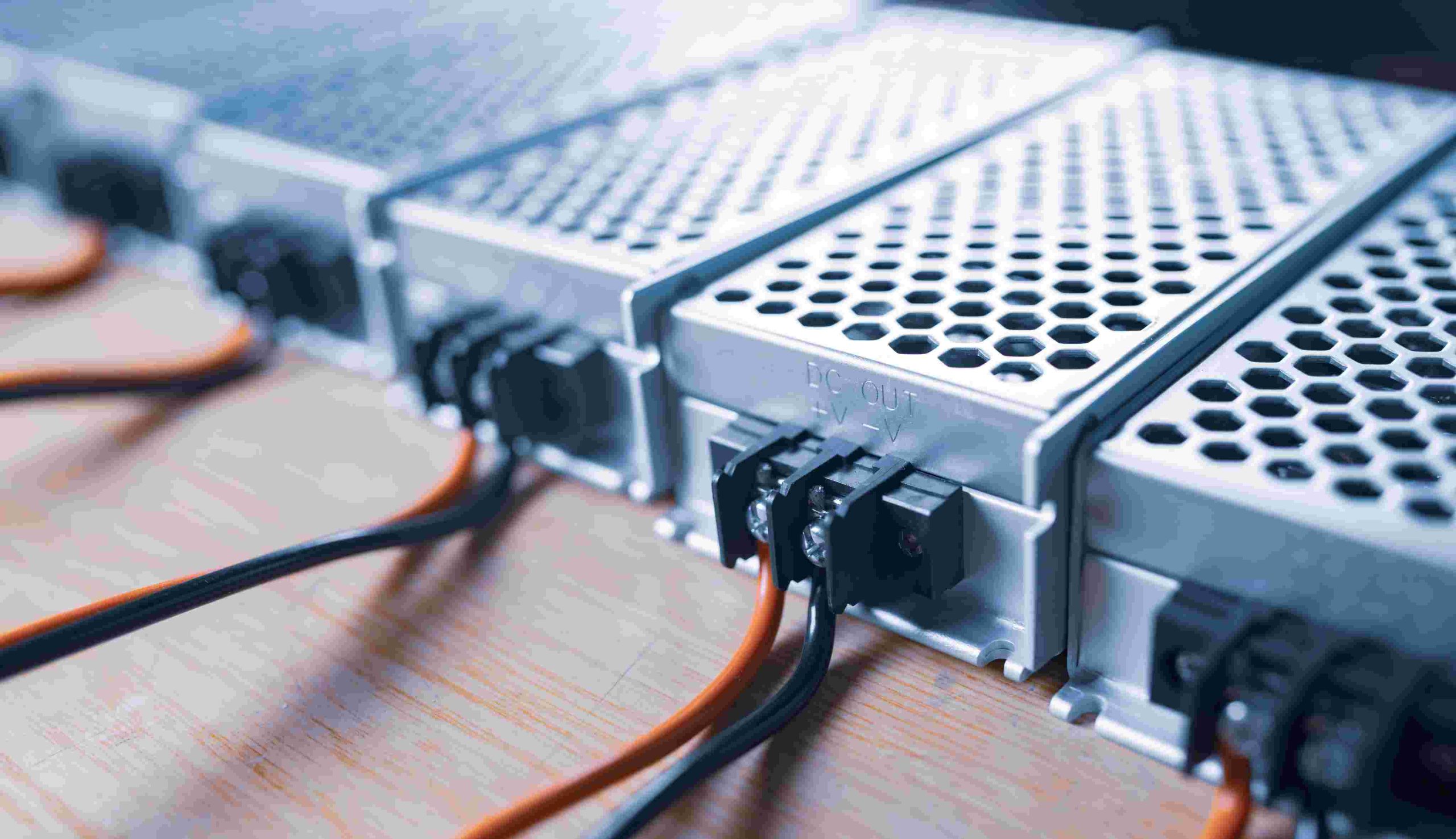 Close-up of three power supply units with wires connected