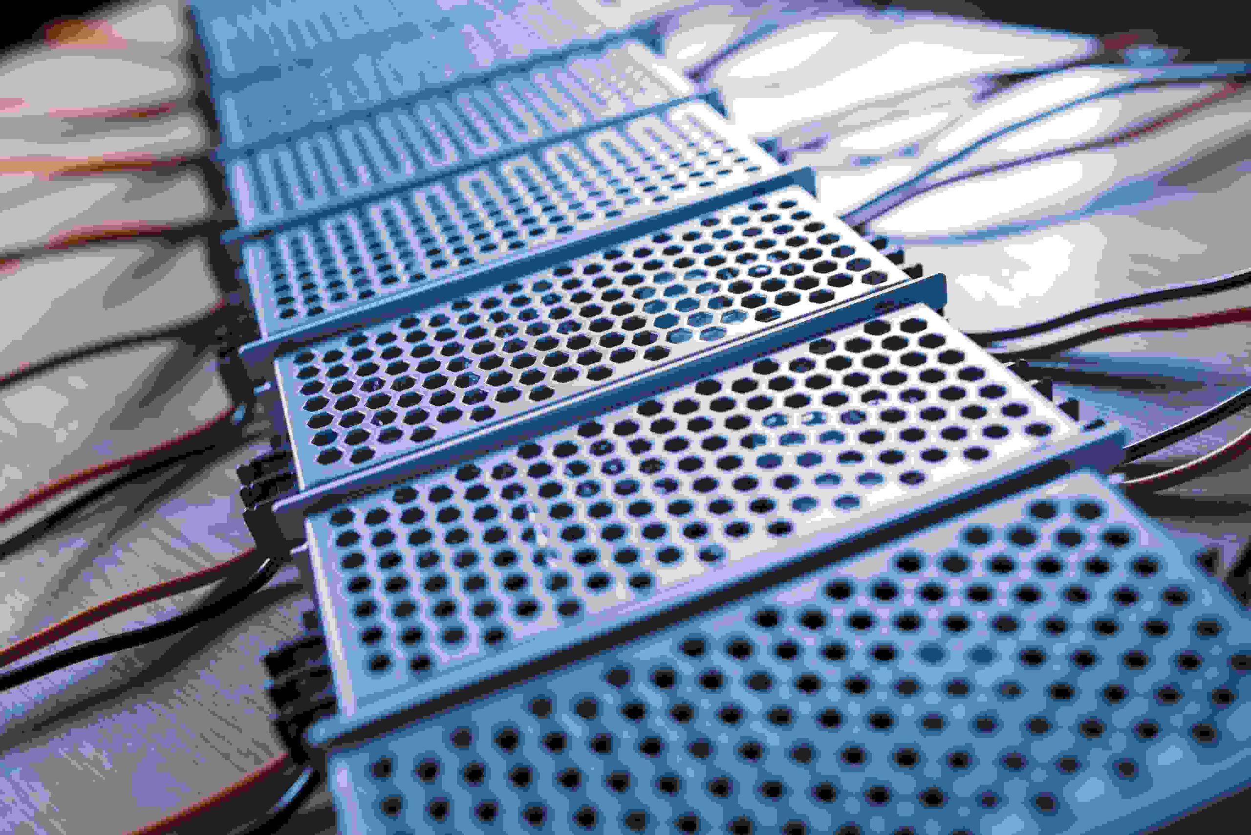 Close-up of several blue metallic grates with hexagonal holes