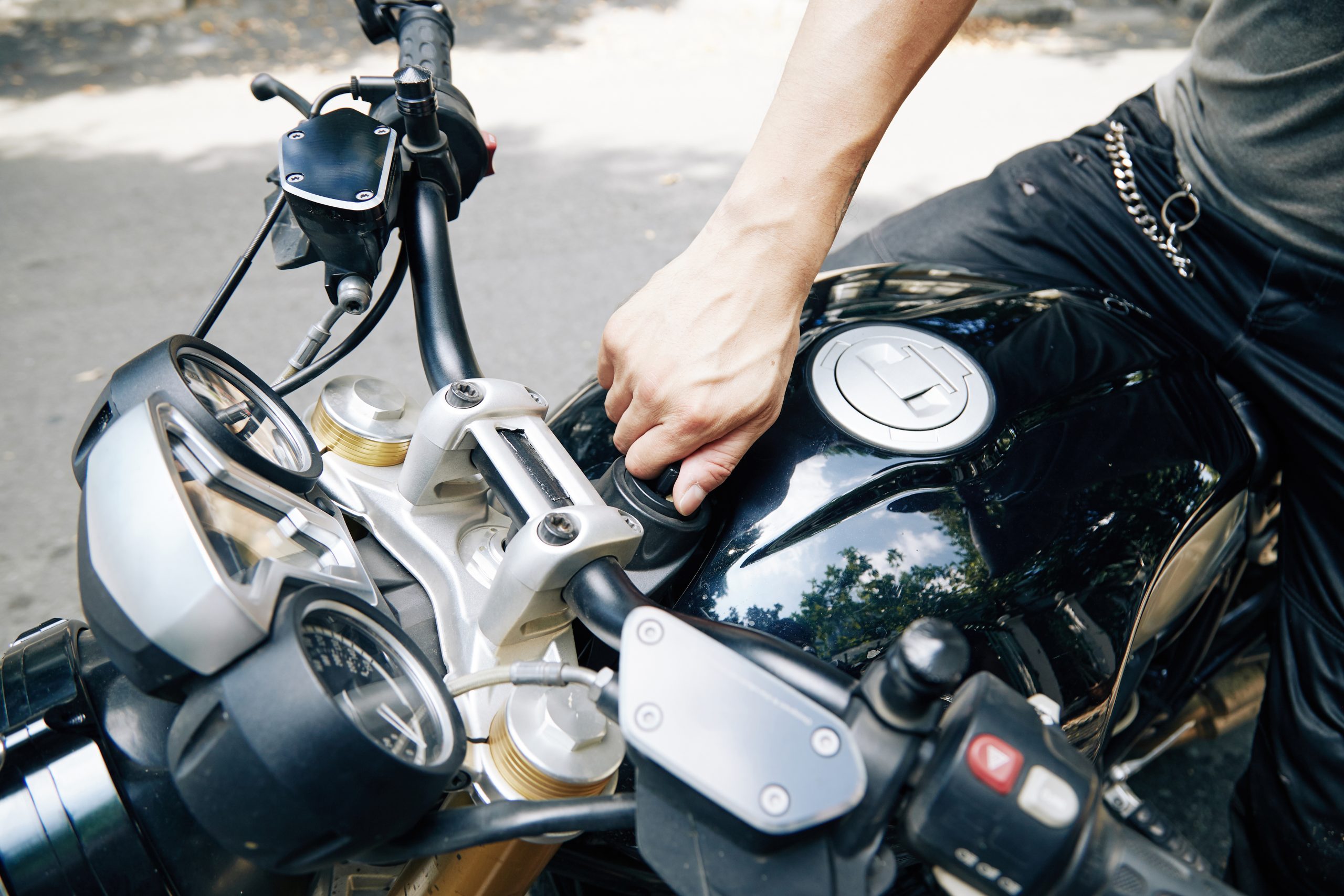 Person's hand on a motorcycle fuel tank, close-up view.