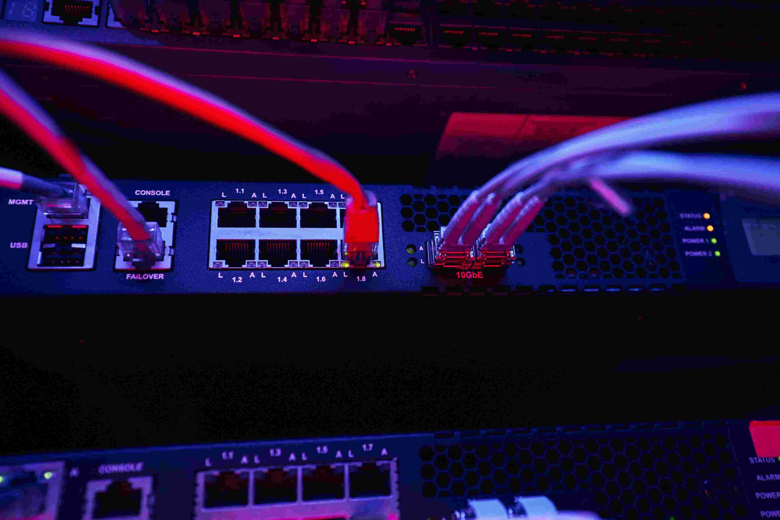 Close-up of network switches with red and white cables connected.