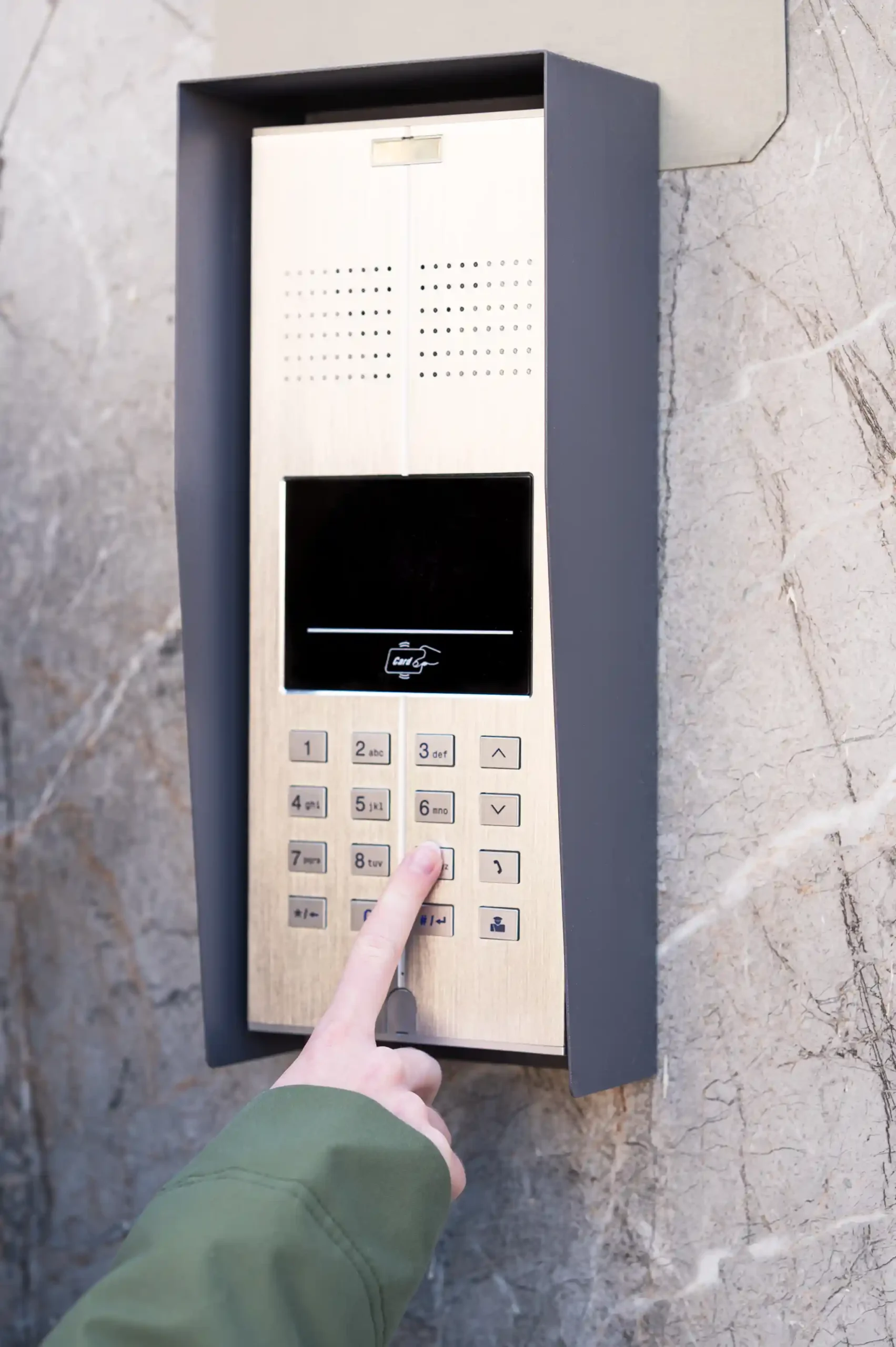 Person pressing a button on a modern building intercom system